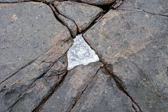 Water that freezes inside cracks in a rock may widen the cracks.