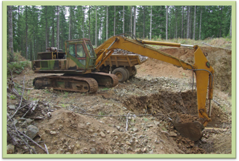 [A excavator working in a borrow pit.]